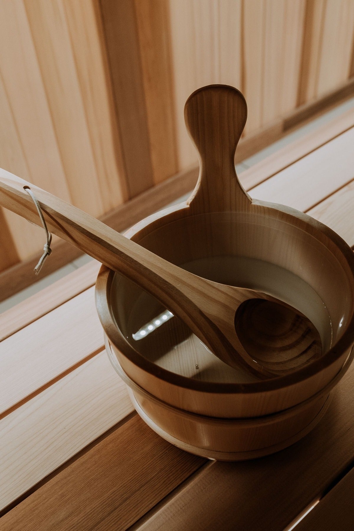 Wooden bucket and ladle on a cedar bench