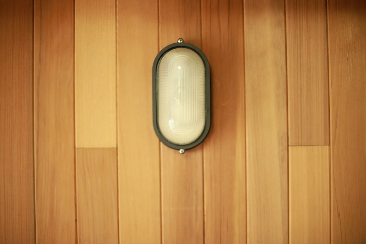 Oval sauna light with frosted cover and protective cage
