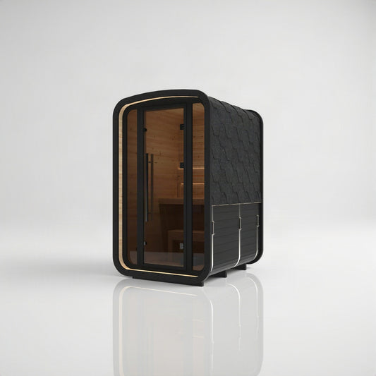 Hekla Mini Cube Nero outdoor sauna, front-right three-quarter view in black-stained thermo spruce with black shingle roof