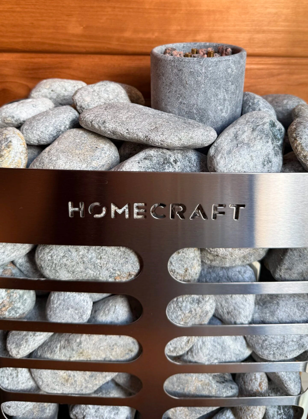 Grey soapstone sauna rocks in a heater cage