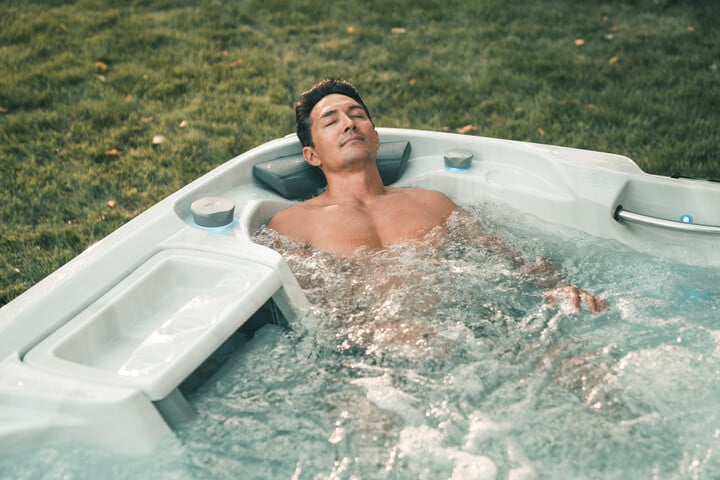 Man relaxing in sundance spa, enjoying the hot tub benefits