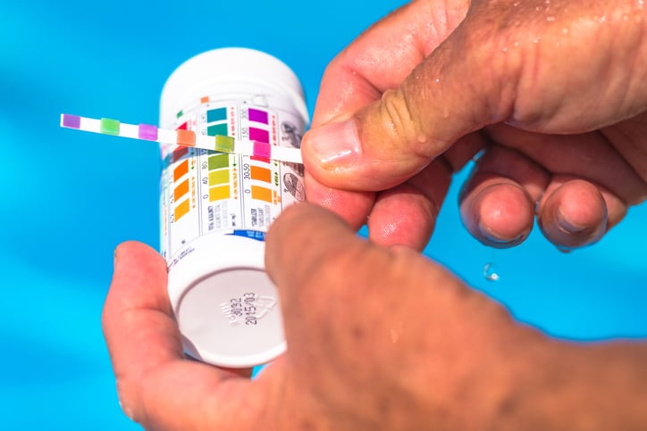 man checking The pH Of A hot tub