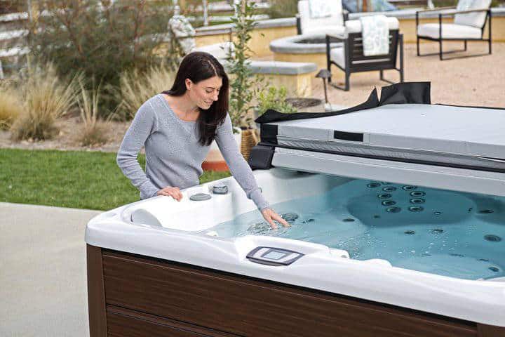 Woman checking her hot tub water during her spa maintenance routine